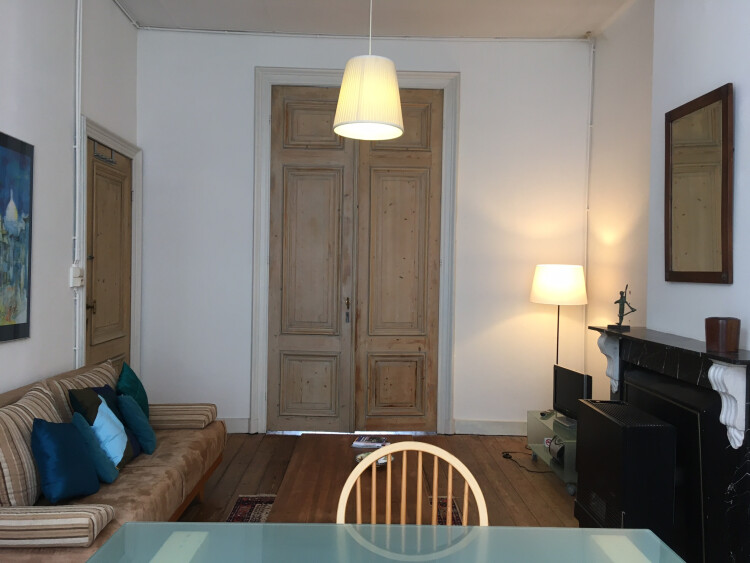 Woonkamer houten planken vloer, marmer schouw, zitbank, salon tafel, eettafel met stoelen